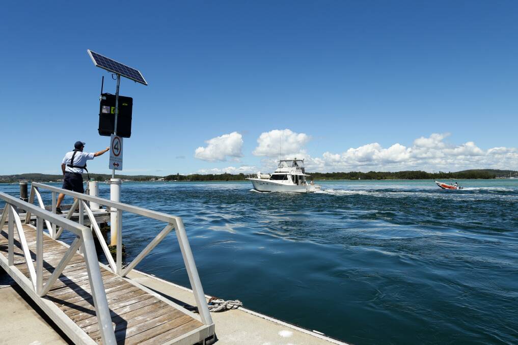 Boating safety officer Chris Austen points out the speed limit to a passing vessel. Picture: Jonathan Carroll