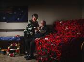 MATES: Maroba resident Gloria Pattison adjusts the poppy she knitted, which is being worn by Alf Carpenter. Pictures: Marina Neil