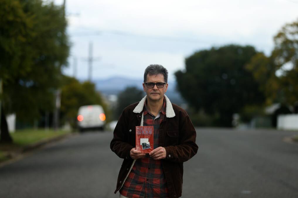 Author John Hughes in Cessnock, holding a copy of his first book, "The Idea of Home". Picture: Jonathan Carroll