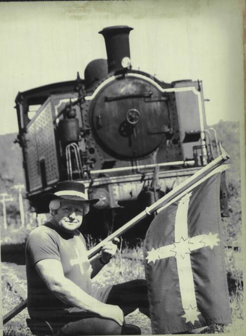 Ray Cross holds a Eureka flag in front of the locomotive that was at the centre of the workers' protest. 
