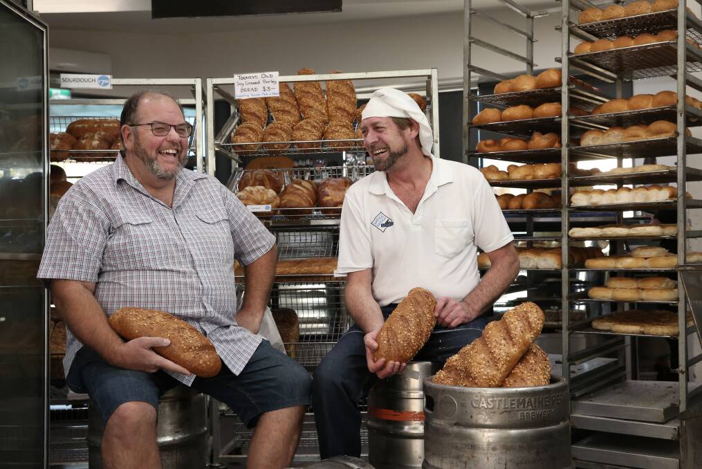 Wayne Izzard, from Wangi RSL Club, and David Woods, co-owner of Wangi Wangi Bakehouse, with loaves of beer bread. Picture: Simone De Peak 