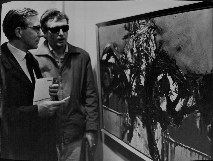 Tom Gleghorn (right) discussing his painting, 'Eyes of a Dove', with Daniel Thomas, from the Art Gallery of NSW, in 1965. 