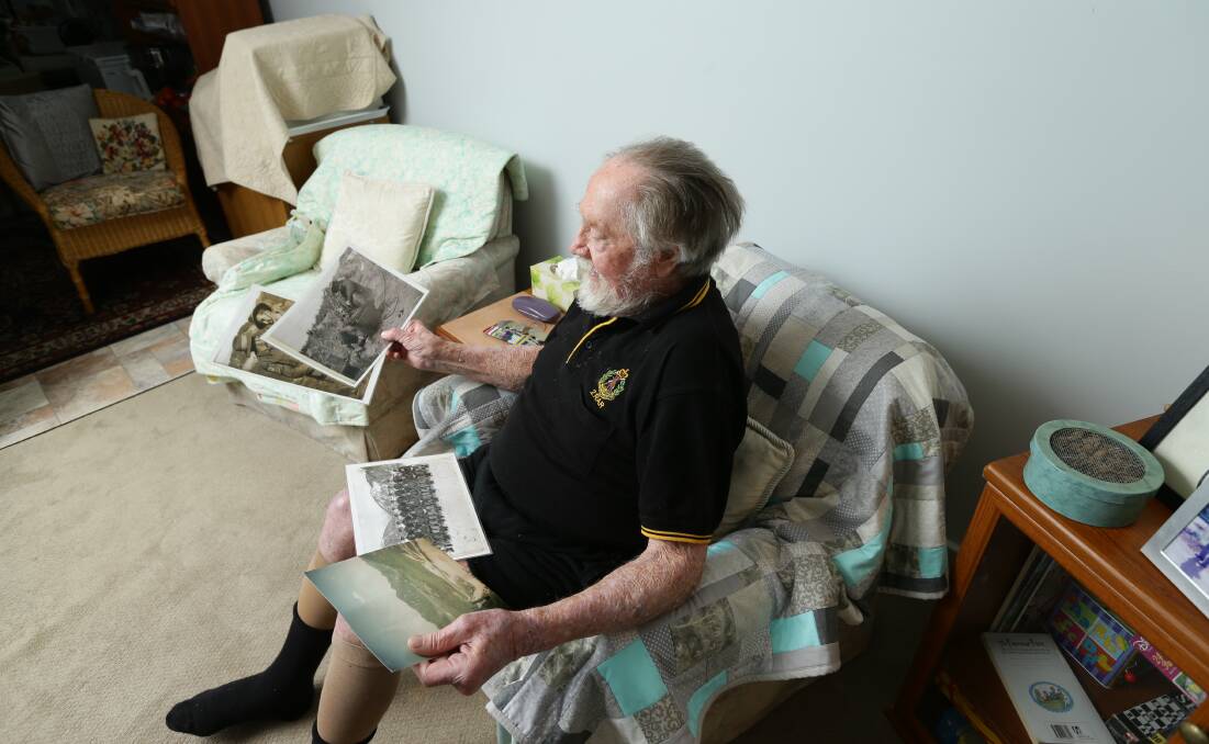 MEMORIES: Gerald Minett looks at photos of his time serving in the Australian army during the Korean War. 