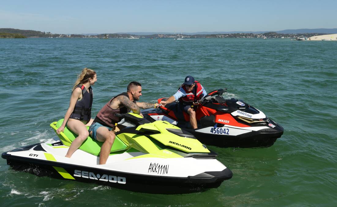 CHECK: Jet ski rider Joey Middleton hands over his licence to boating safety officer Chris Austen.