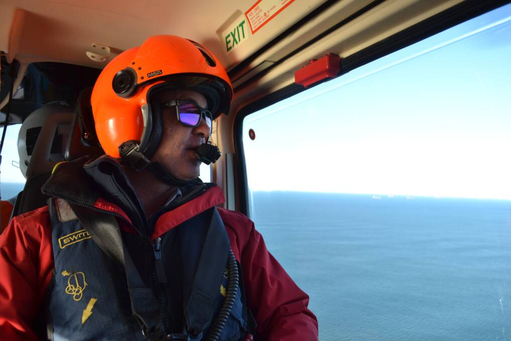 Marine pilot Captain Mark Webb being transported by helicopter to a ship. Picture: Scott Bevan
