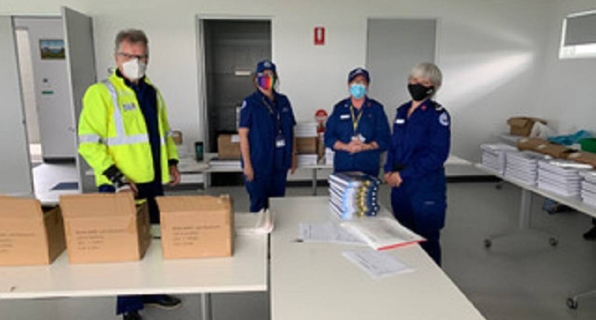 BUSY: Marine Rescue Lake Macquarie volunteers packing copies of the new book. Picture: Lee Baines 