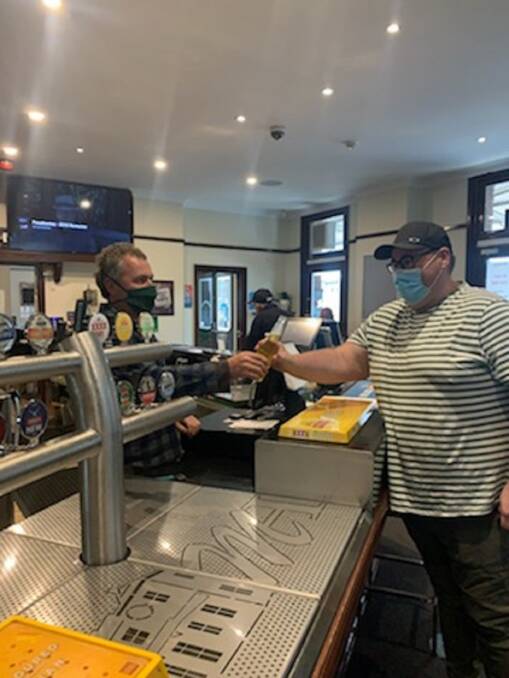 CHEERS: The Muswellbrook Hotel publican Daniel Keegan serves a customer. Picture: Courtesy, Col Caldwell 