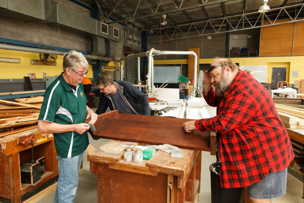 CREATING: Newcastle Men's Shed president Neville Pollock talks with member Drew Davison about a woodworking project, while secretary Wayne Grant looks for materials. Pictures: Max Mason-Hubers