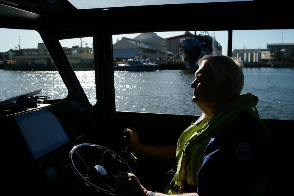 Ron Calman, the long-serving unit commander of Marine Rescue Newcastle, at the helm of the boat named after him. Picture: Jonathan Carroll 