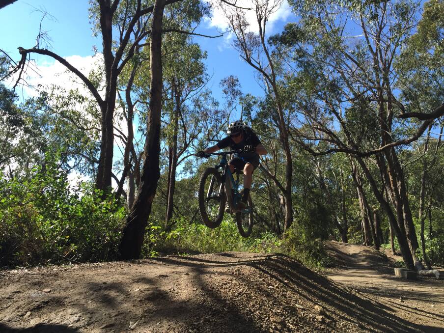 Mick Plummer riding over the 'table top' mounds at Six Shooter in Glenrock State Conservation Area. Picture: Scott Bevan