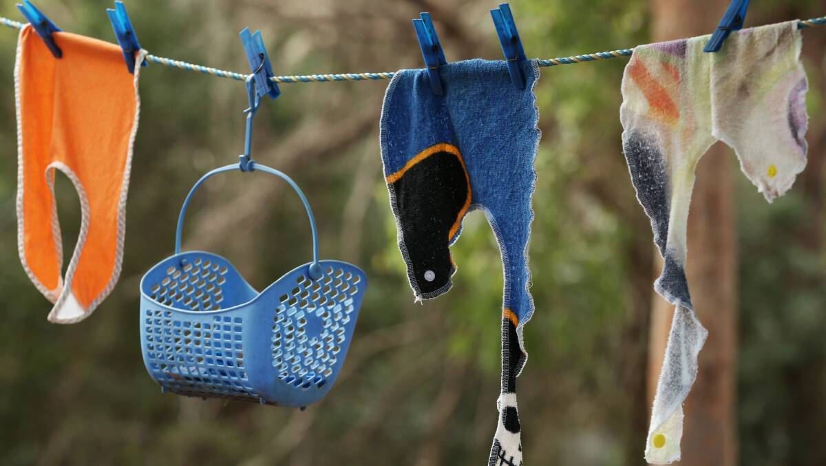 Tiny bibs, used while feeding the koalas, hang on a washing line. Picture: Simone De Peak