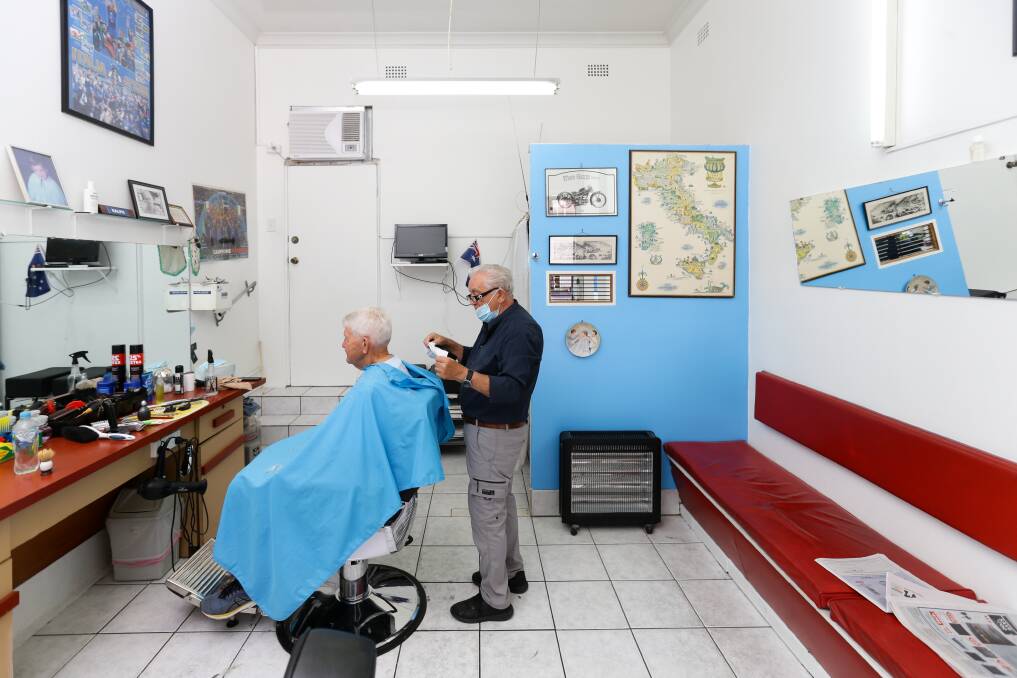 Ralph Della Grotta cutting hair in his Beaumont Street, Hamilton, shop. Picture: Jonathan Carroll 