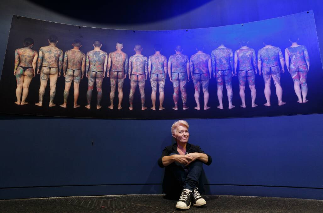 Julie Baird in front of an exhibition about the art of Japanese tattoos at Newcastle Museum in 2017. Picture: Max Mason-Hubers