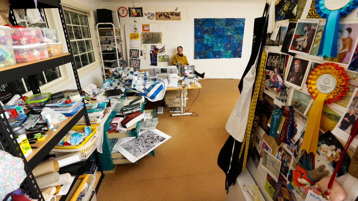 Artist Judy Hooworth amid the stacks of textiles and her photo albums and sketch books in her home studio at Morisset. Picture: Jonathan Carroll
