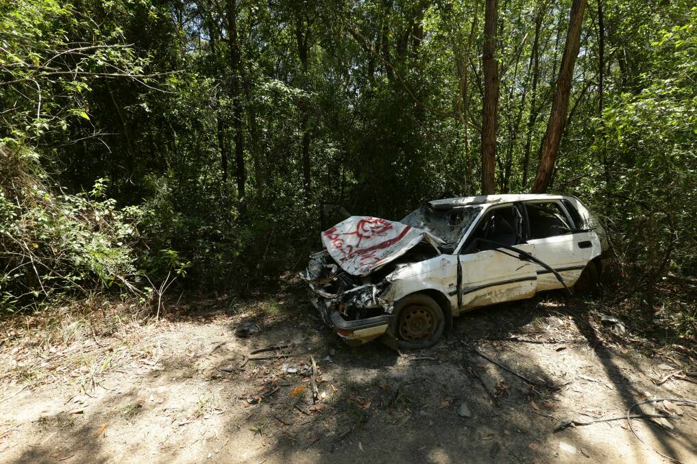 A trashed and abandoned car on the proposed Richmond Vale Rail Trail. Picture: Jonathan Carroll 