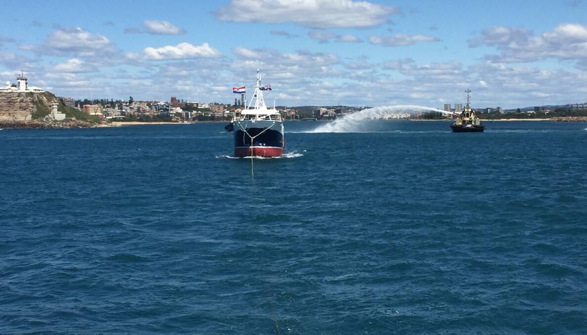 The 'Betts Bay' tows the new fishing boat out of the harbour, with a Svitzer tug providing a water salute. Picture: Scott Bevan