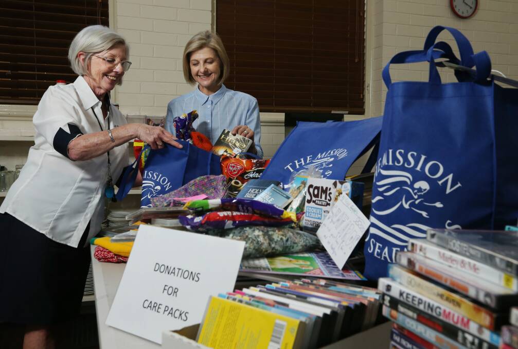 Dianne Terry and Bernadette Barry pack care packages at Newcastle's Mission to Seafarers. Picture: Simone De Peak
