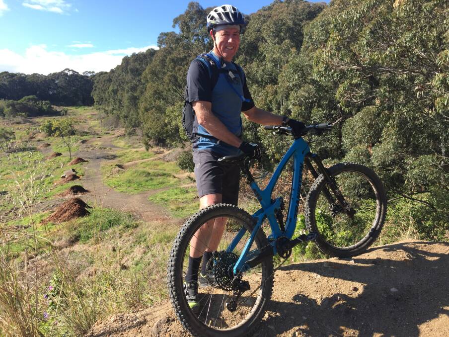 Mick Plummer, with the trail known as Seismick in the background, at Glenrock. Picture: Scott Bevan