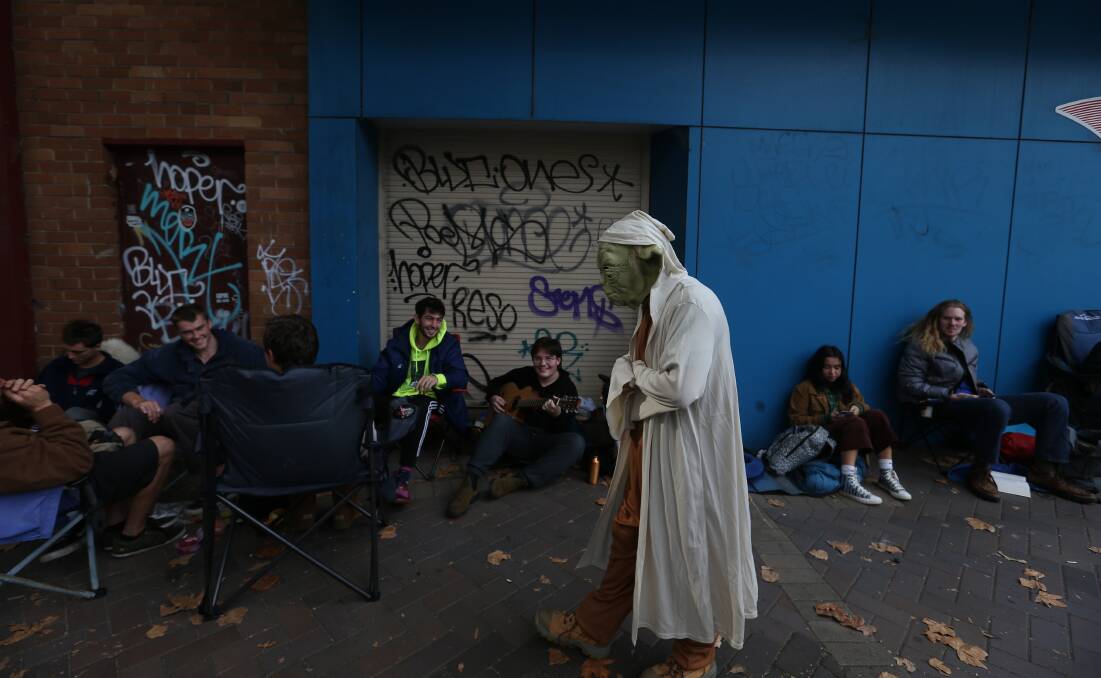 A queue of people - and Yoda - wait for the doors to open on the annual "May the Fourth Be With You" sale at Muso's Corner. Picture: Marina Neil 