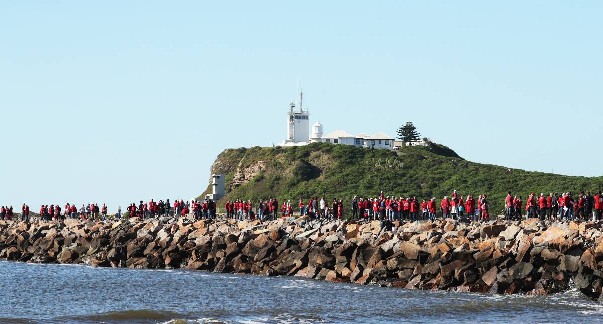 Hundreds line the northern breakwater in July to protest the erosion issue along Stockton beach. Picture by Peter Lorimer