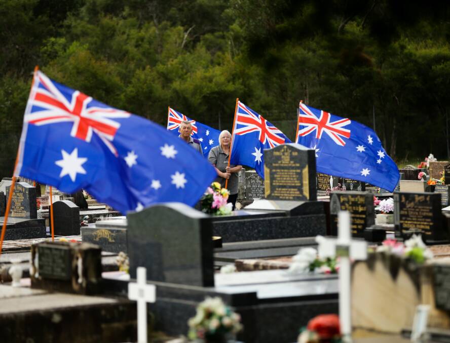 Coalfields Local History Association members Bill Holland and Cheryle Shoesmith set up the Field of Honour in Kurri Kurri cemetery. Pictures: Jonathan Carroll