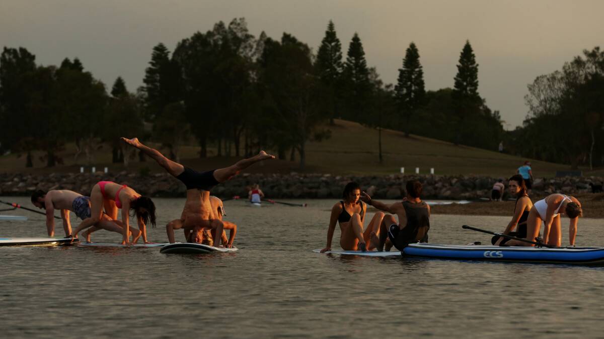 A group practising yoga on paddle boards on Throsby Creek. Picture: Simone De Peak