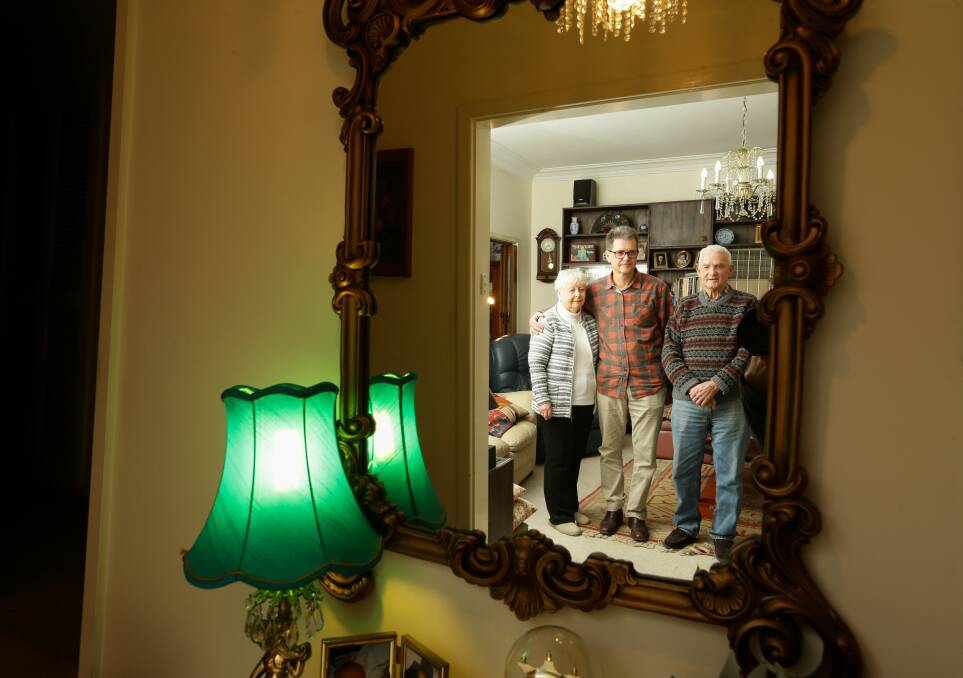 Author John Hughes with his parents, Val and Bob, in the family home at Cessnock. Picture: Jonathan Carroll