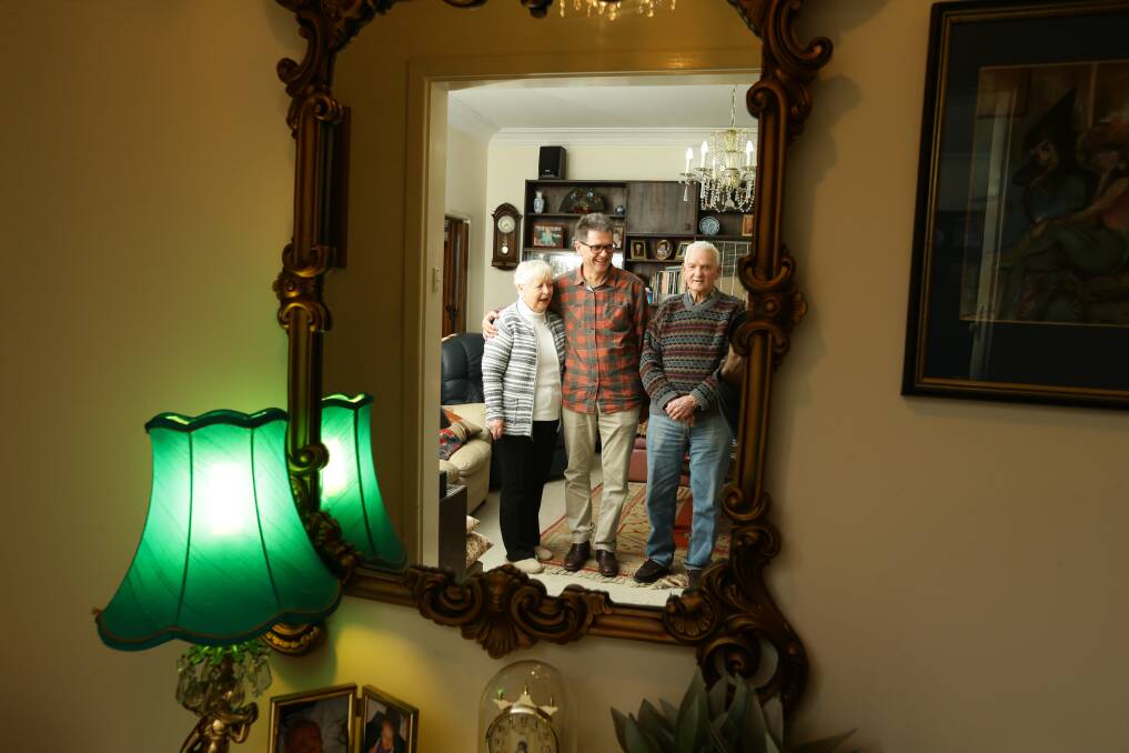 Author John Hughes with his parents, Val and Bob, in the family home at Cessnock. Picture: Jonathan Carroll