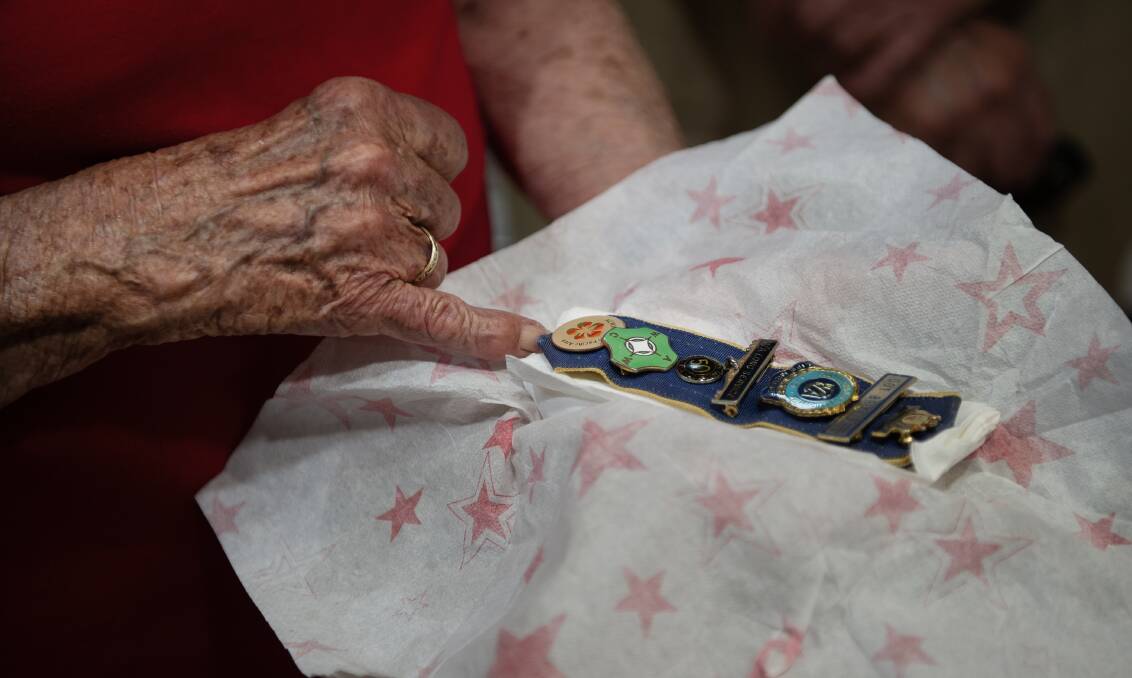 Doris "Dot" Brittliff looking at some of her service badges. Picture: Marina Neil