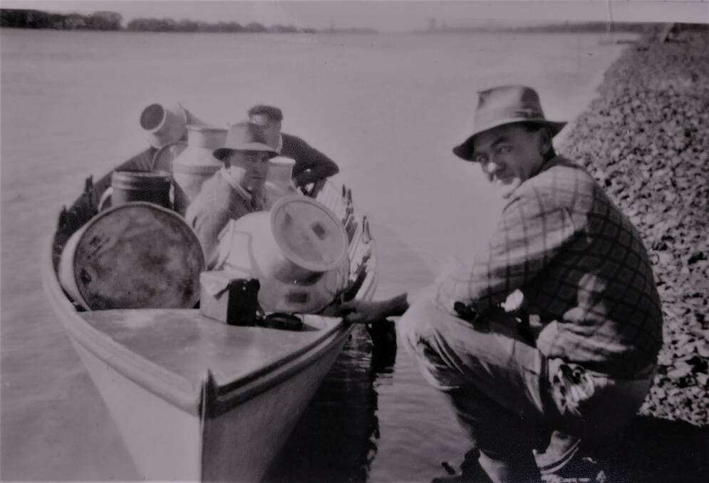 Don Wilson and his father, Bronco, transporting milk from Ash Island during a 1950s flood. Picture: Courtesy, Don Wilson