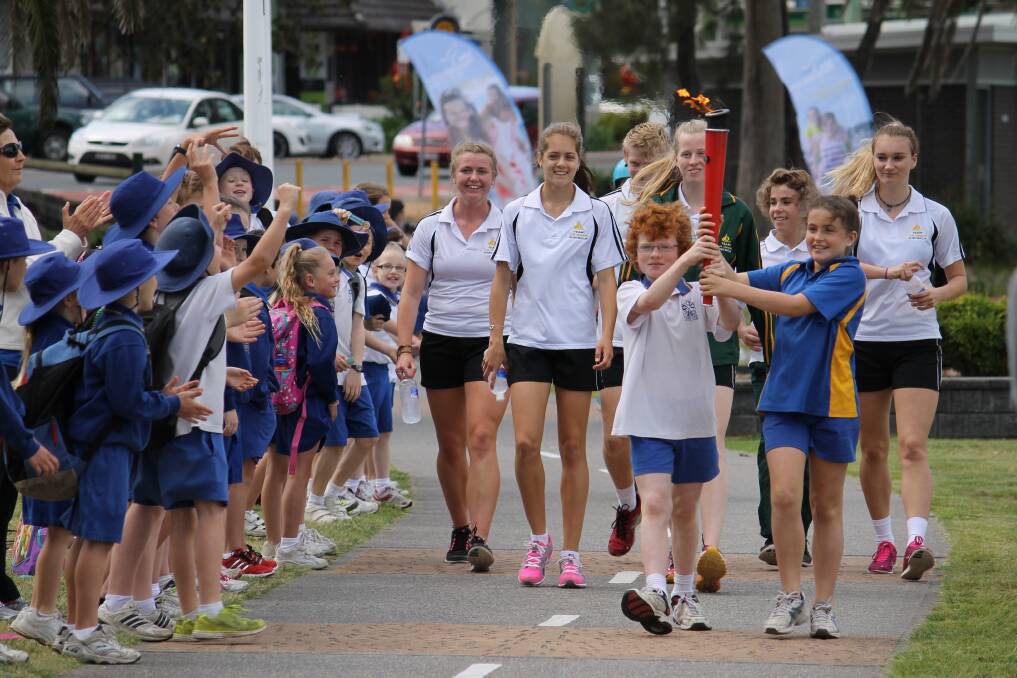 St Kevin's Primary School students carry the 2014 International Children's Games torch.