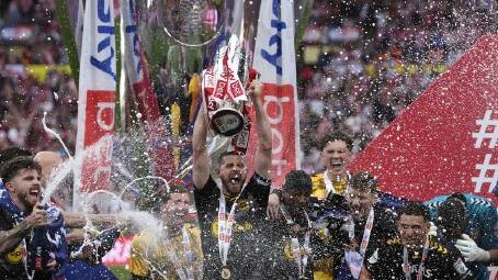 Southampton's Jack Stephens lifts the trophy above his teammates after their Wembley triumph. (AP PHOTO)