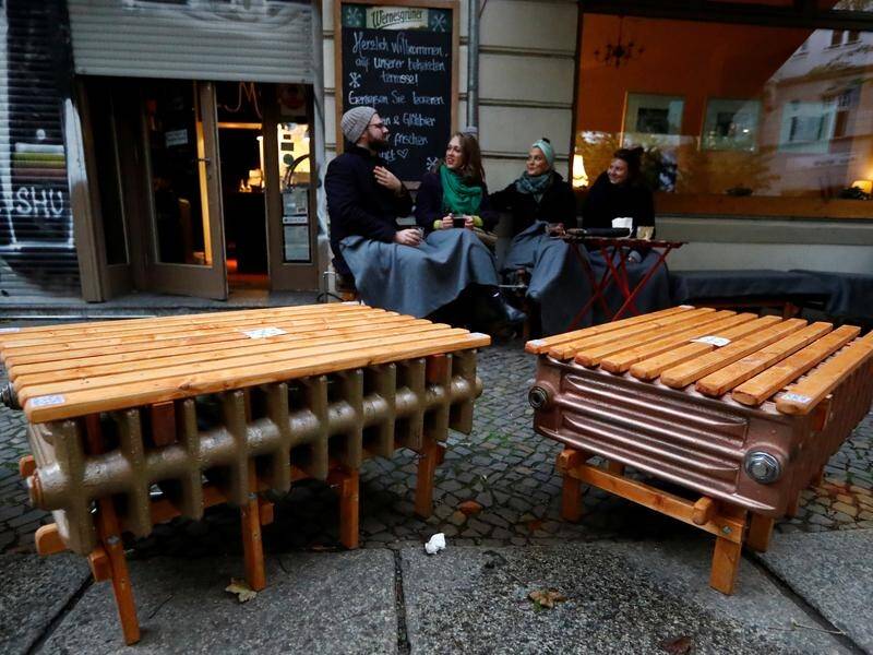 Guests at a Berlin restaurant sit on heated benches that allow dining outside even in cold weather.