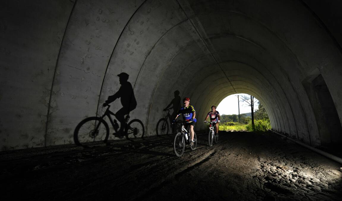CYCLE TRAIL IDEA: Cyclists pedal through the modern, but unused, concrete rail tunnel on the former Richmond Vale Railway line, now proposed for reuse.   Picture: Marina Neil