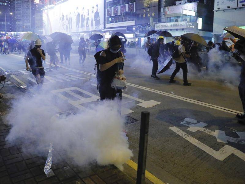Hundreds of protesters in Hong Kong have taken cover after police fired rubber bullets and tear gas.