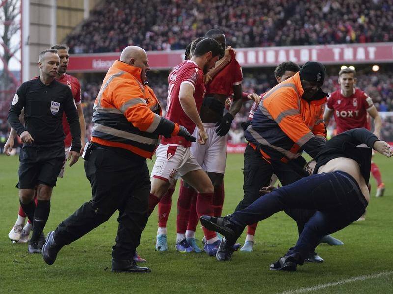 Pitch invaders, like the fan who attacked Nottingham Forest players, now face an automatic ban. (AP PHOTO)