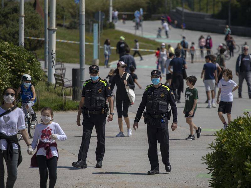 Spanish police officers patrol on the first day young children were allowed to leave their homes.