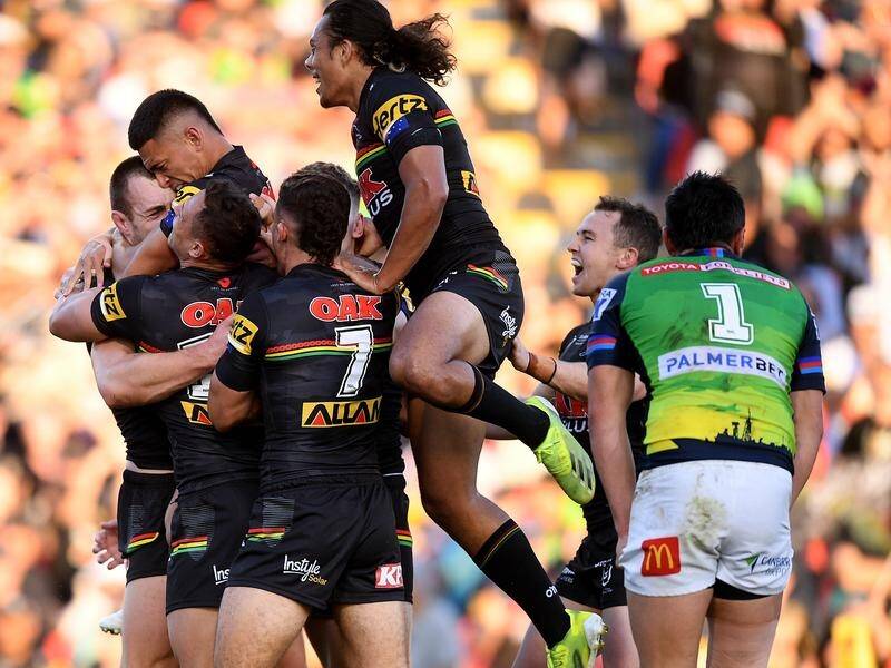 Isaah Yeo of the Panthers (left) celebrates with teammates after scoring a try against the Raiders.