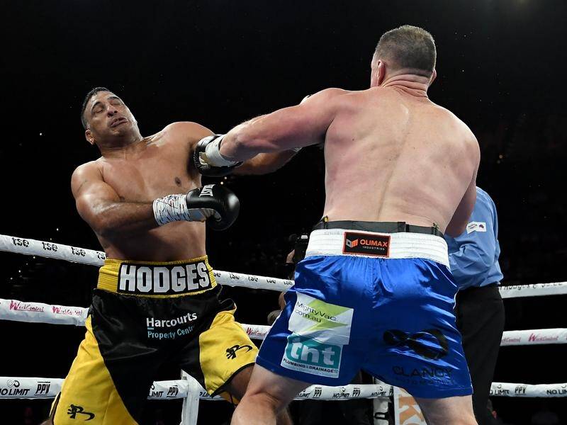 Justin Hodges is rocked by unanimous points winner Paul Gallen in their heavyweight bout at the ICC. (Steven Markham/AAP PHOTOS)