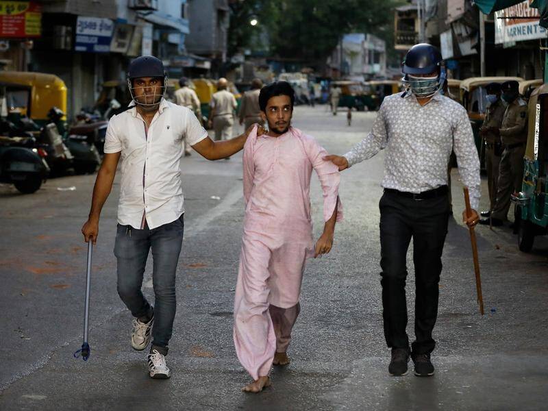 Plainclothes police made arrests in the Indian city of Ahmedabad after a lockdown sparked clashes.