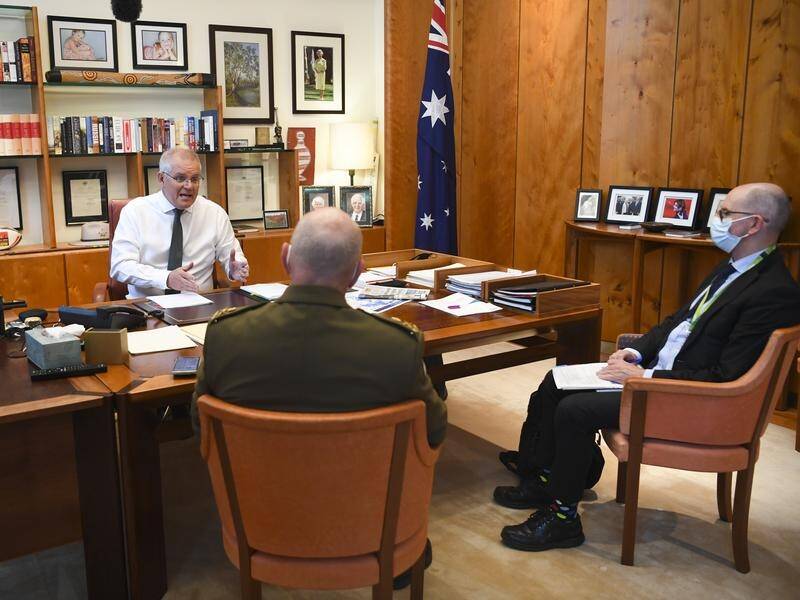 Scott Morrison speaks to Chief Medical Officer Paul Kelly (r) and COVID-19 lead John Frewen.