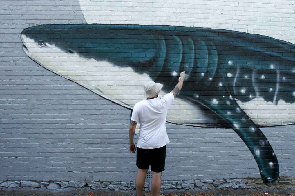 OCEAN SCENE: Artist Numskull working on his piece  in Laman Street, Cooks Hill.