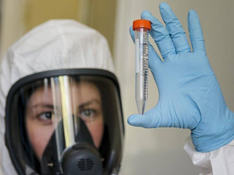 A Russian lab technician holds the first government-approved coronavirus vaccine.