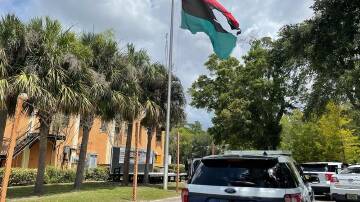 The flame-damaged Pan-African flag flies outside the headquarters of the Uhuru Movement in Florida.