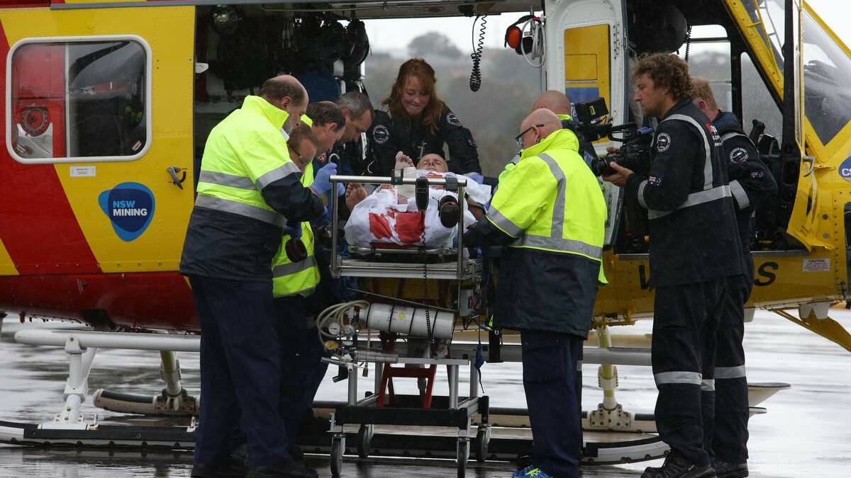 Medics work to stabilise shark attack victim David Quinlivan before he was flown by rescue helicopter to John Hunter Hospital. Picture: Peter Stoop