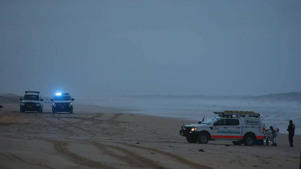 Police on Stockton beach on Friday evening after the bodies were found washed ashore.
Picture: Peter Stoop