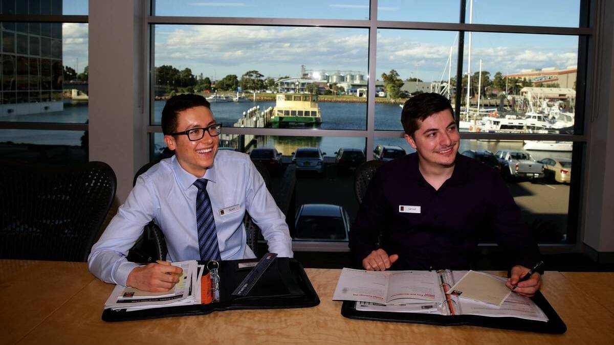 WORK EXPERIENCE: University of Newcastle students Scott Cawley and Jarrod Glover at work at NAB Wickham as part of the bank’s second paid industry placement program.   Picture: Jonathan Carroll
