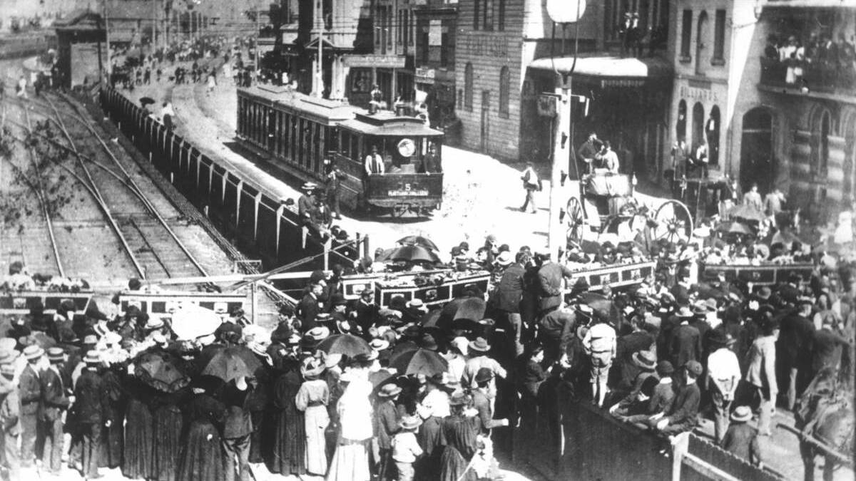 PROCESSION: The coffins of miners carried past Newcastle’s Market Street railway gates to cross Scott Street towards the present Hunter Street Mall. 