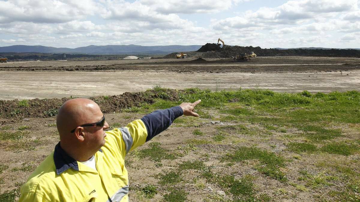 Remediation of the old Pasminco lead works site at Boolaroo.  Pasminco worker Robert Simmons pointing to work happening on the 'Cell' where contaminated soil is gathered .
