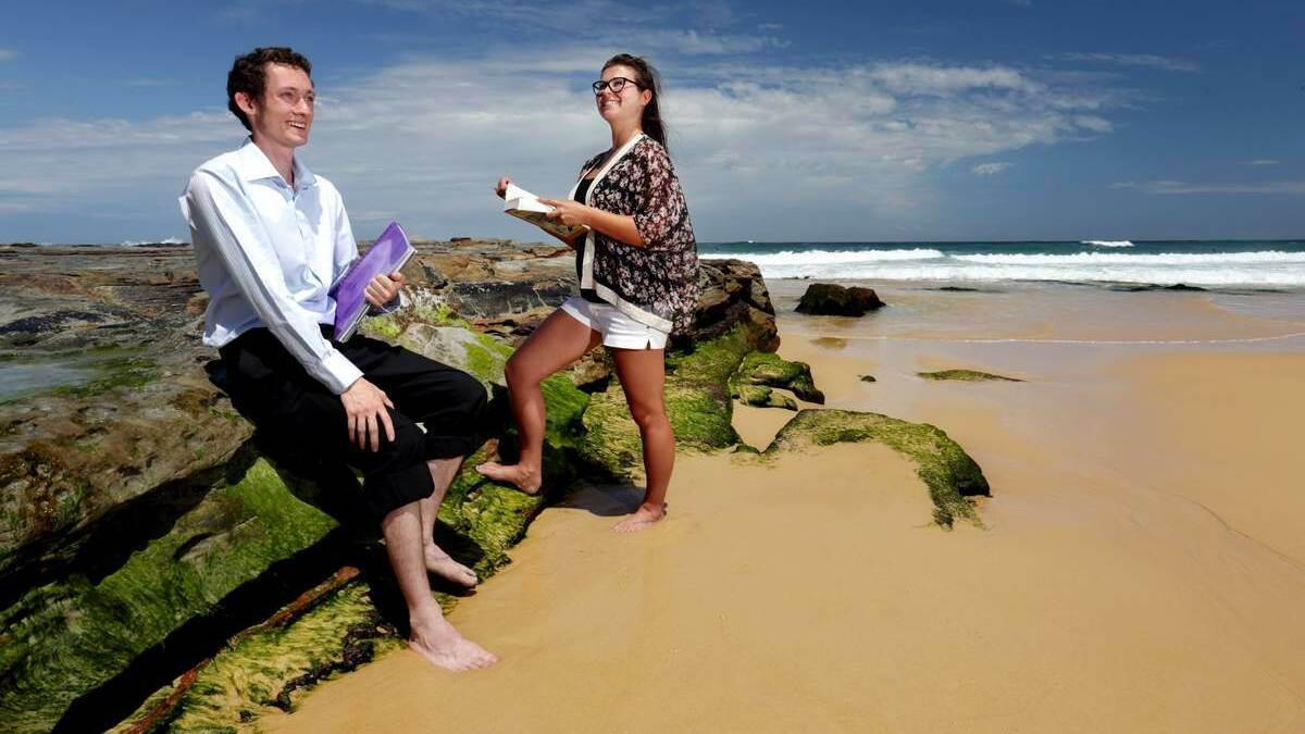 AT WORK: Newcastle University students Matthew Freestone and Amber Albrecht on Newcastle beach as part of Law on the Beach where students offer free legal advice.
